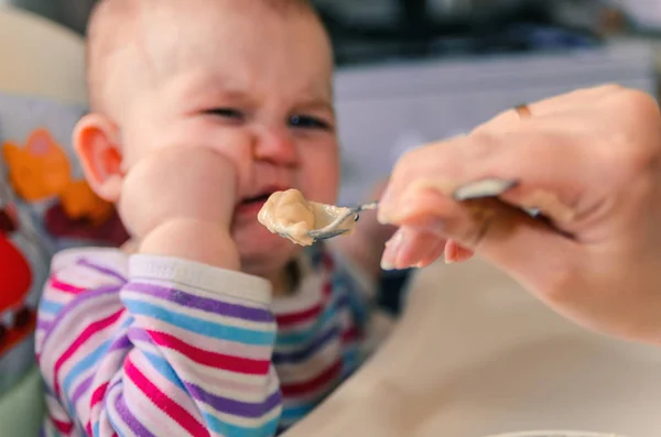 A mãe dá a comida de bebê de uma colher — Fotografia de Stock