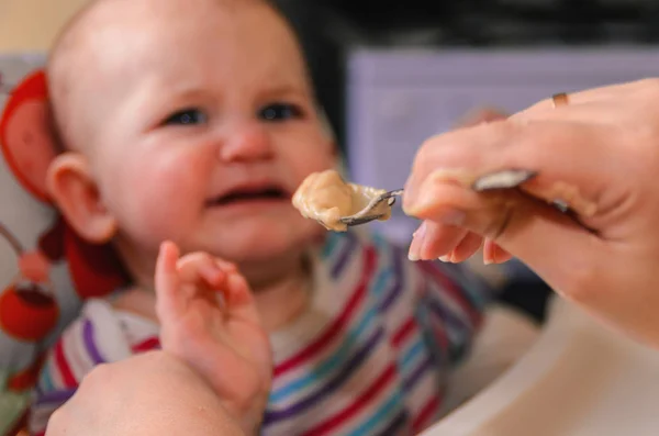 A mãe dá a comida de bebê de uma colher — Fotografia de Stock