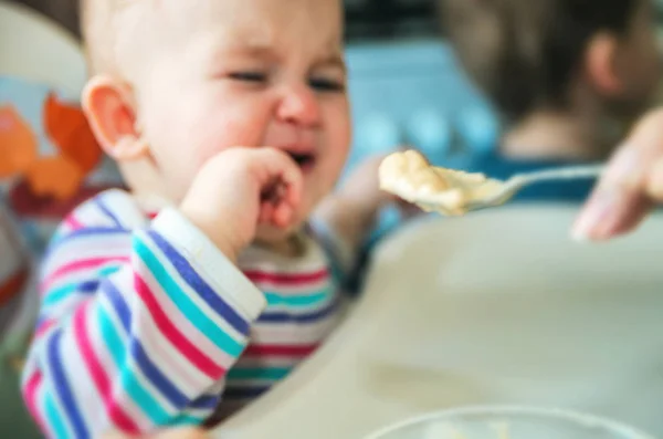 A mãe dá a comida de bebê de uma colher — Fotografia de Stock