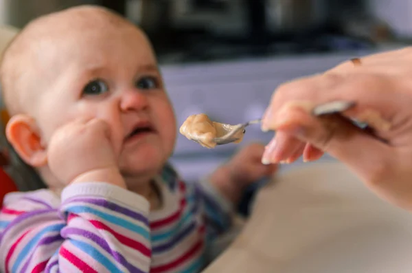 A mãe dá a comida de bebê de uma colher — Fotografia de Stock