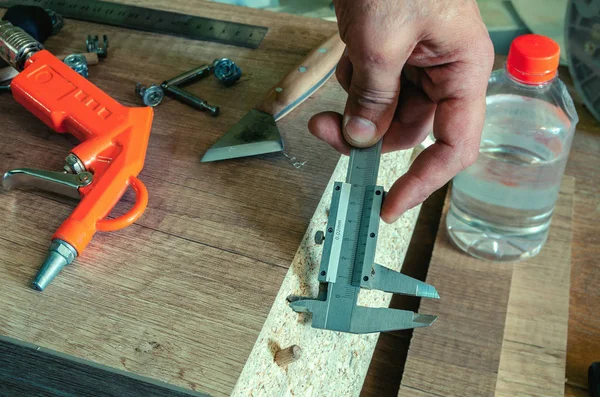 Carpintero mide los agujeros hechos con una pinza — Foto de Stock