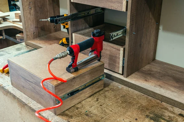 Roter Drucklufthefter in einer Möbelwerkstatt — Stockfoto