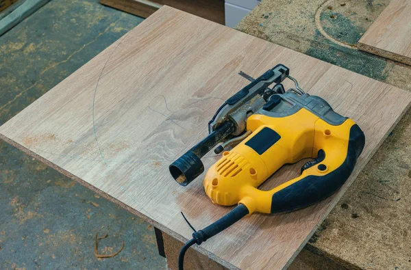 Electric jig saw cuts the workpiece from chipboard for furniture — Stock Photo, Image