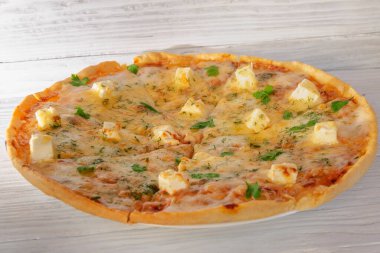 Peynirli sebzeli pizza ve ahşap arka planda et.