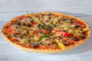Peynirli sebzeli pizza ve ahşap arka planda et.