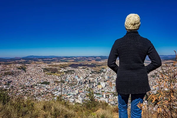 Fotoğrafta dağın tepesindeki kadın Pocos de Caldas - Minas Gerais / Brazil - aşağıdaki şehri izliyor.. 