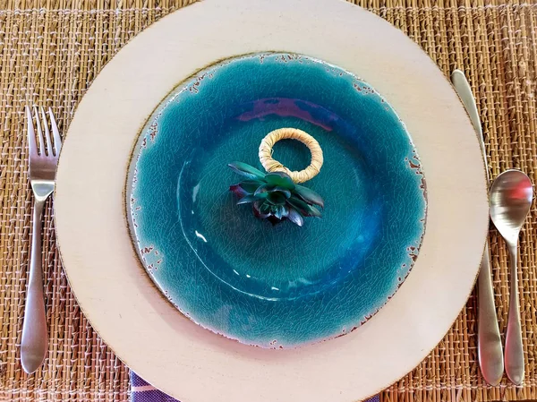 blue floral napkin ring on plate with silverware and placemat