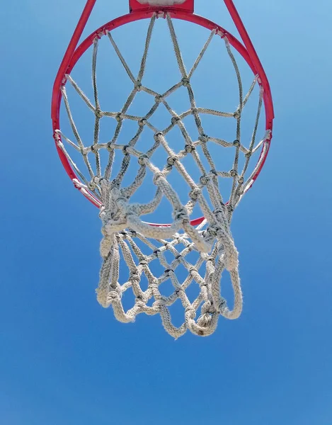 明るい青い空を背景にバスケット ボールのフープの底面ビュー — ストック写真