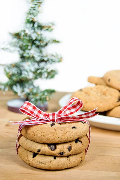 赤と白のギンガム チェックのリボンとクリスマス ツリーと弓で結ばれたチョコレート チップ クッキー — ストック写真