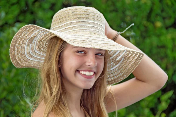 在绿色的树林里带着夏日帽子微笑着十几岁的白种女孩 — 图库照片