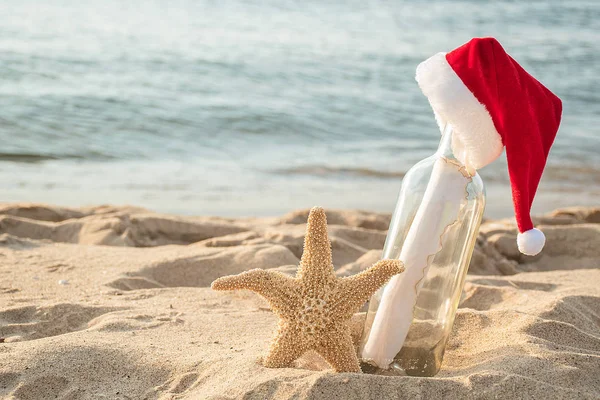 Czerwone Białe Futro Boże Narodzenie Kapelusz Wiadomość Butelce Rozgwiazdy Plaży — Zdjęcie stockowe