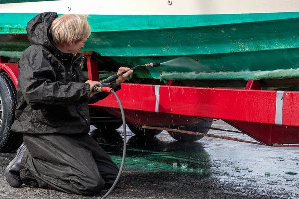 Kaukázusi Férfi Térdelt Míg Magas Nyomású Mosó Piszkos Hajótestre Piros — Stock Fotó