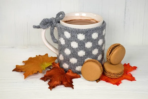 热巧克力饮料在杯子与灰色和白色圆点针织毛衣和杏仁饼上秋叶 — 图库照片