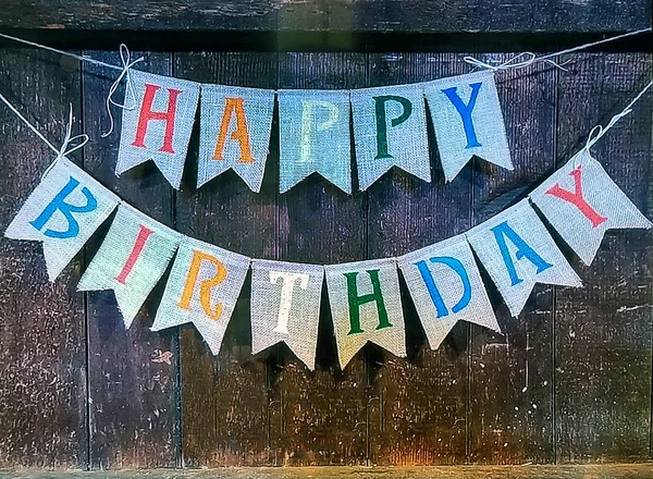 happy birthday banner sign hanging on rustic wooden wall