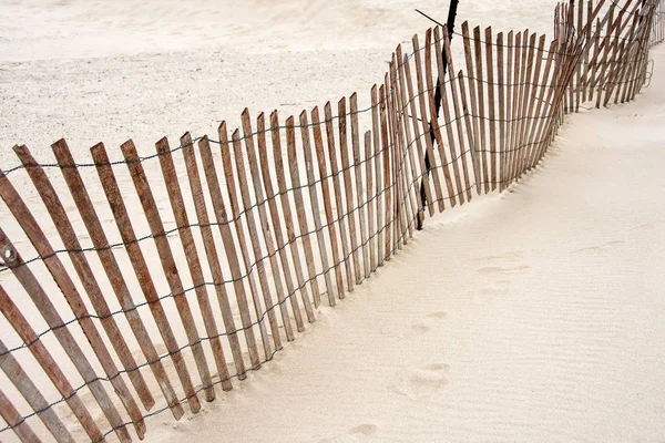 倾斜风化的旧木栅栏在沙滩上的沙子 — 图库照片