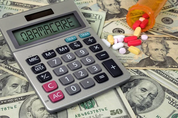 電卓とオレンジ色の薬瓶からこぼれ出るほど処方薬の様々 なアメリカのお金に関する医療制度改革テキスト — ストック写真