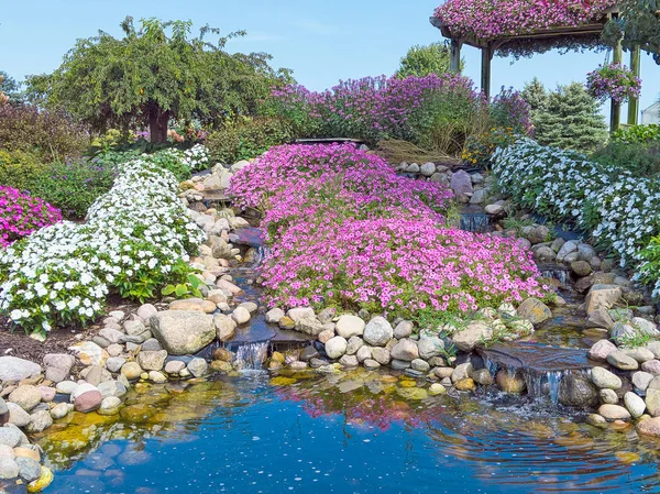 Piscina Agua Jardín Roca Ornamental Con Cascadas Petunias Rosadas Impacientes — Foto de Stock