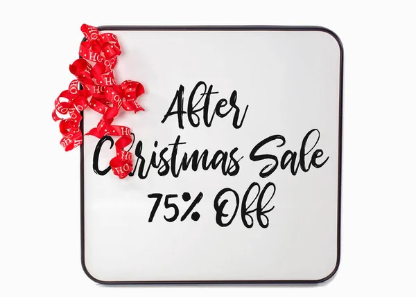 after Christmas sale sign with red curly ribbon on white dry erase board