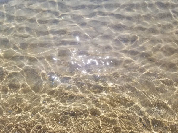 明るい日光が澄んだ浅い湖の水面にまぶしい — ストック写真