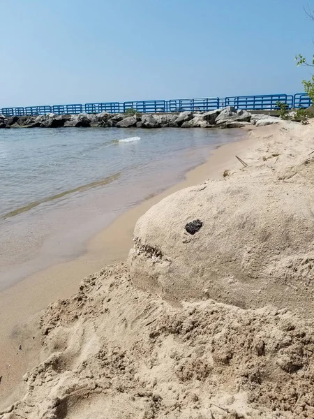 ミシガン湖のビーチで貝殻の歯を持つサメの砂の彫刻 — ストック写真