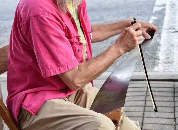 老人在街上用锯子唱着歌 — 图库照片