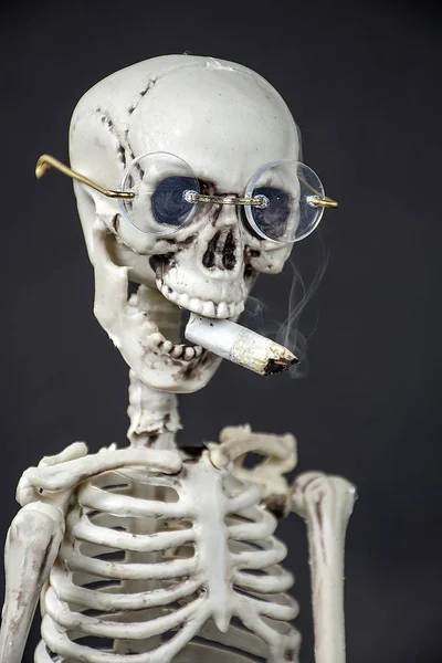 Κοντινό Πλάνο Σκελετού Φορώντας Γυαλιά Καπνίζοντας Ένα Τσιγάρο Μαύρο Φόντο — Φωτογραφία Αρχείου