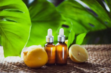 Şişe limon yağı, taze meyve bütün ve yarı tropikal doğal bir arka plan üzerinde.