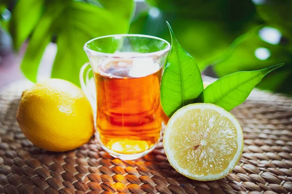 Fruits tea made from Limon , organic tea , fresh limon fruits whole and half on a natural tropical background.