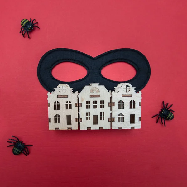 Crime in the city concept, black criminal mask, spiders on the background of the houses of the city. View from above, flat lay