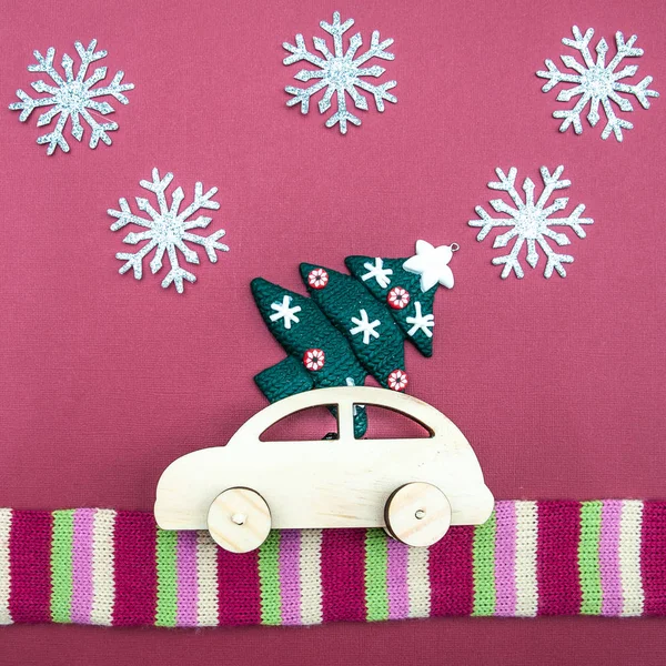 Stylish wooden car with a Christmas tree on a plain background. Minimalism, View from above, flat lay