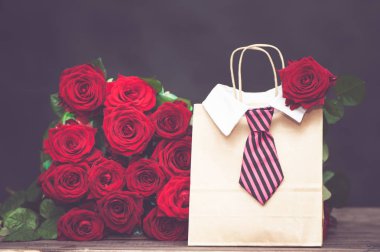  Kavramı bir adamdan aşıkların günü için bir hediye. büyük kucak dolusu kırmızı gül ve erkekler kravat hediye çantası.
