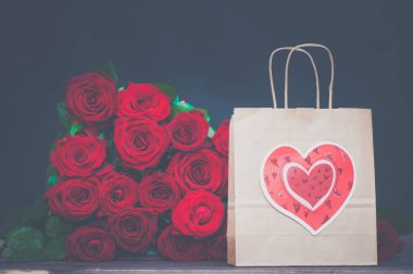  büyük demet kırmızı gül ve kalbi olan bir hediye çanta. Düğün, Sevgililer, aşk, tarihi için bir hediye kavramı