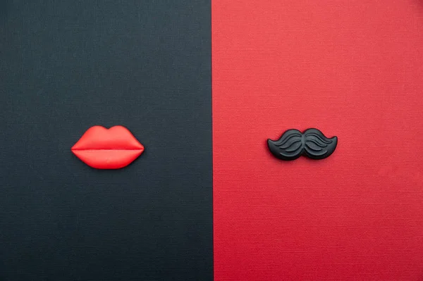 concept of male and female. Flat Lay, red and black, red lips and black mustache, as a symbol of man and woman. Valentine day love