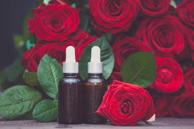 Gül yağı, şişeleri ve taze çiçek ve yaprakları doğal zemin, bio, organik, doğal kozmetik kavramı