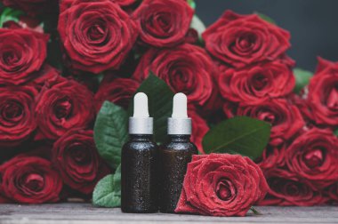 Gül yağı, şişeleri ve taze çiçek ve yaprakları doğal bir b