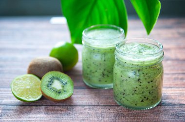 Kivi smoothies cam bardak ahşap bir masa üzerinde