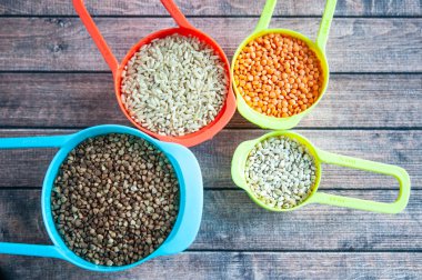 Çok renkli kaplarda, yulaf ezmesi bu farklı tahıl kümesi