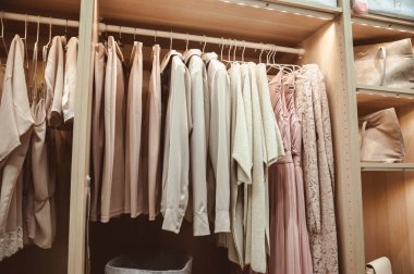 Modern ahşap gardırop ve rayüzerinde asılı giysiler. Depolama ve