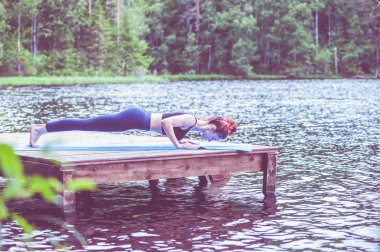 Genç yogi kız yoga, dört bacaklı personel yapıyor, sohbet