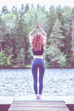 Genç yogi kız yoga, Hasta Uttanasana gölde pratik
