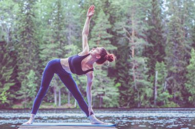 Yogi kız yoga, Utthita Trikonasana egzersiz yapıyor, e