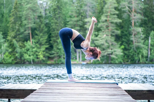 Junges Mädchen beim Yoga in der Natur am See. Weibchen hap — Stockfoto