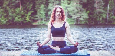 Gölde yoga pozu alan güzel kız. Lotus pozisyonu , Pad