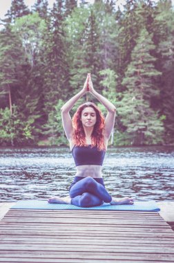 Yoga yapan genç bir yogi kızı, Gomuk 'un varyasyonunda oturuyor.