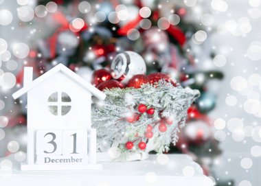 Noel ağacının arka planında ahşap bir takvim var. 