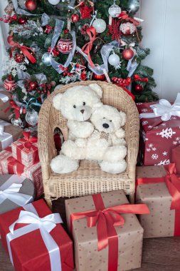 Kutular kırmızı renkli bir Noel ağacının altında kurdelelerle bağlanmış. Sy.