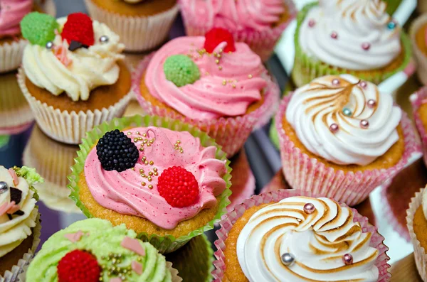 Sabrosos cupcakes sobre una mesa de madera blanca — Foto de Stock