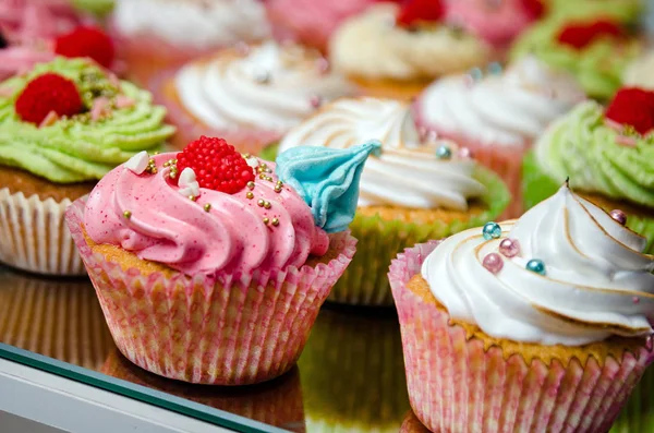 Sabrosos cupcakes sobre una mesa de madera blanca — Foto de Stock