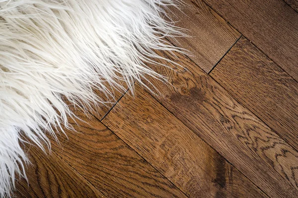 Decorative fur carpet on wood floor — Stock Photo, Image