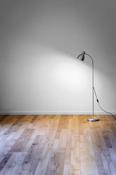 Lâmpada de assoalho de metal na sala vazia com sombra na parede branca, espaço de cópia para texto — Fotografia de Stock